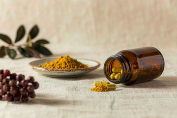 Berberine benefits: amber bottle, golden capsules and herbal powder with barberry berries on cream linen.