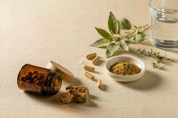 Ashwagandha side effects: amber jar, ashwagandha roots, capsules, powder dish, water glass